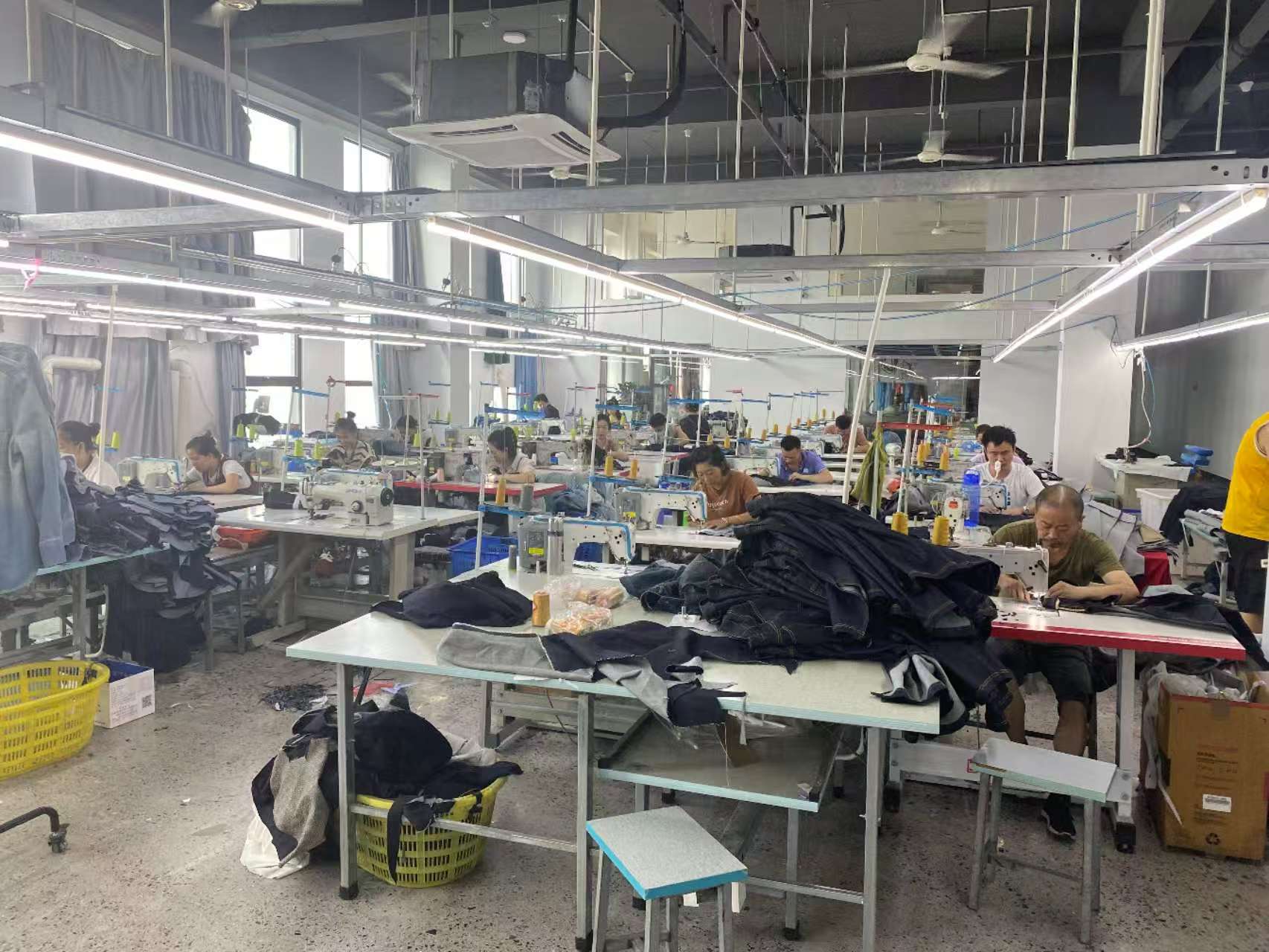 Operators working at garment sewing workstations during production