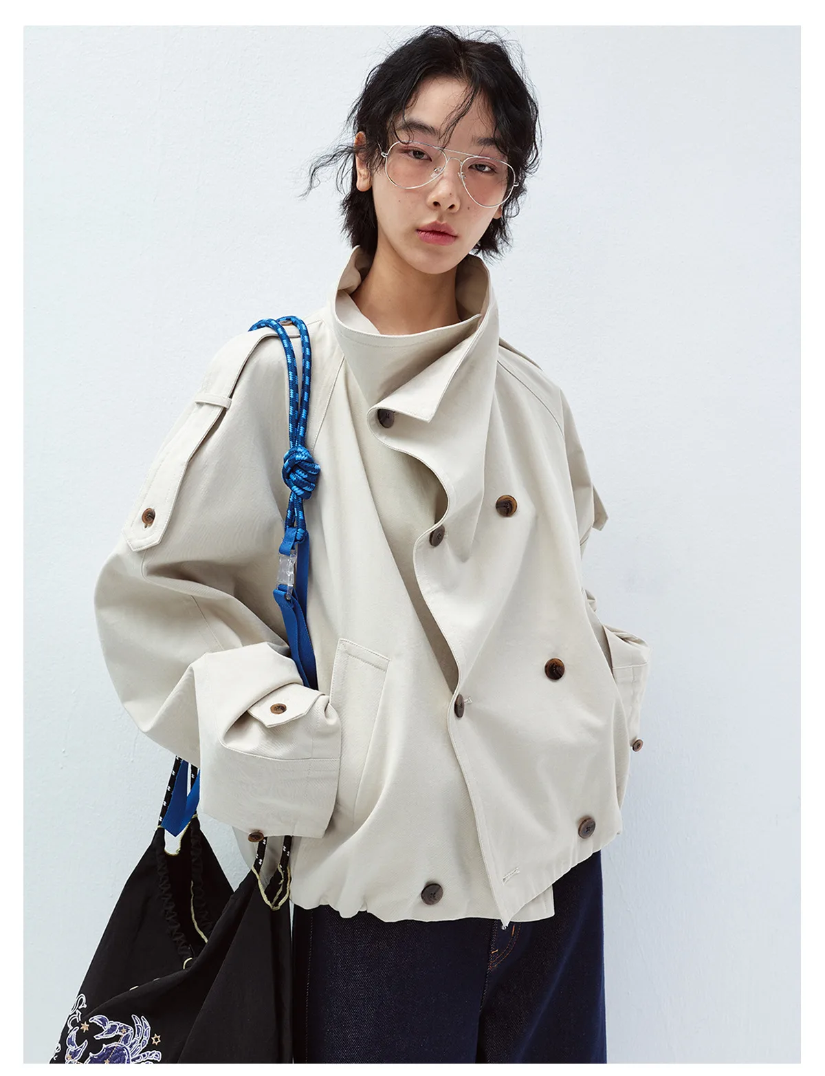 Woman wearing a light beige short double-breasted trench jacket