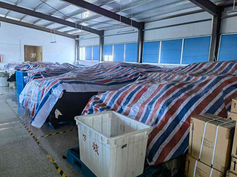 Covered fabric rolls in the material storage area of an evaluated apparel production facility