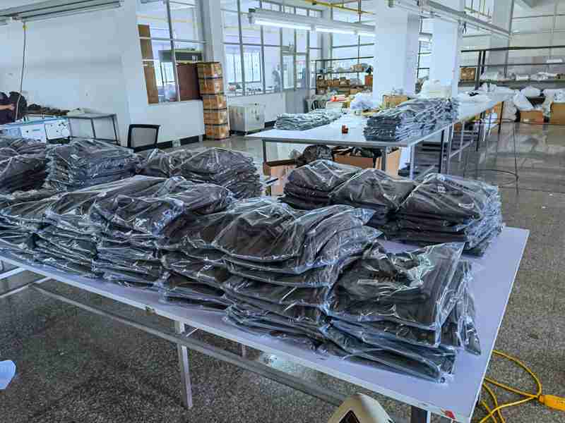 Bagged finished garments staged in the packing area of an evaluated production facility